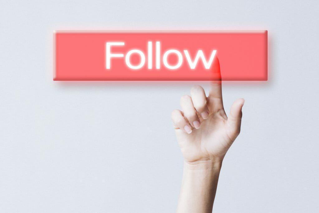 hand clicking follow button social media